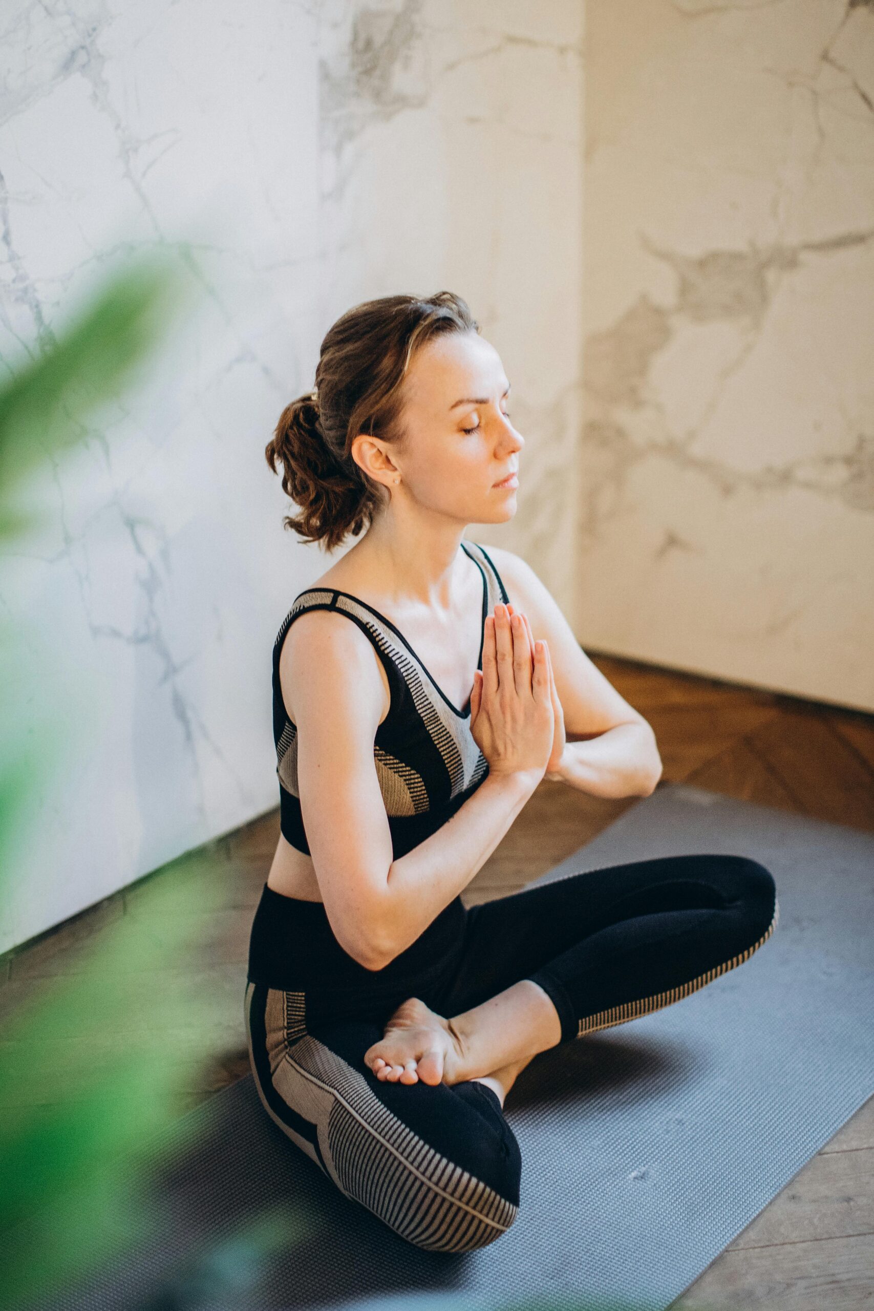 Woman practicing yoga indoors in a peaceful setting, demonstrating mindfulness and relaxation.