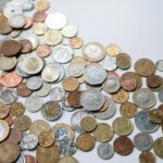 A variety of international coins scattered on a light background, showcasing different currencies.